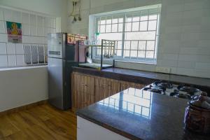 a kitchen with a refrigerator and a counter top at Winterbourne Chalet in Coonoor