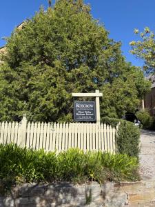 a white picket fence with a sign in front of a tree at Roscrow Heritage Retreat in Clare +1 photo