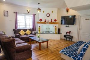 a living room with a couch and a fireplace at Winterbourne Chalet in Coonoor +27 photos