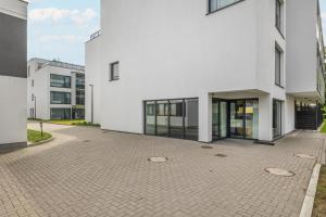 an empty courtyard in front of a white building at Solny Resort Apartament A245 in Kołobrzeg