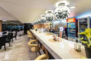 a restaurant with a long bar with chairs and tables at Solny Resort Apartament A245 in Kołobrzeg