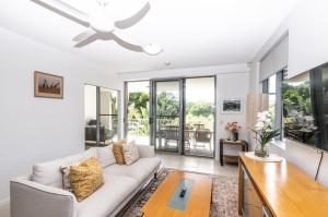 a living room with a couch and a ceiling fan at Drift North Beachfront Apartments - Private Apartments in Kingscliff