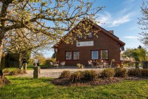 a log cabin with a yard and a house at Familiengasthof Schaller in Floß