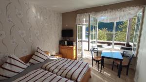a bedroom with a bed and a table and a desk at Ferienhaus Moselpanorama in Ellenz-Poltersdorf