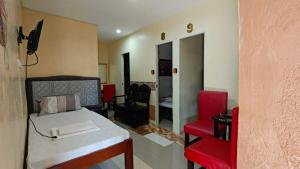 a bedroom with a bed and a red chair at Casa FAM in Laoag