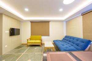 a waiting room with a blue couch and a chair at Mandala Living Kathmandu in Kathmandu