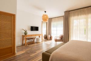 a bedroom with a bed and a desk and a television at Fiora Alacati in Alaçatı