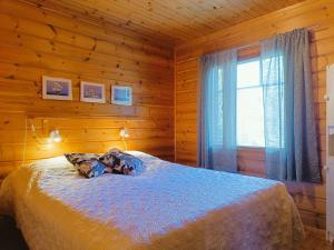 a bedroom with a bed in a wooden cabin at Kulkuri in Syöte