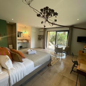a bedroom with a large bed and a large window at Les Petites Maisons in Sotta