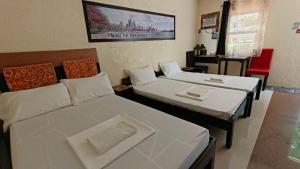 a room with two beds and a red chair at Casa FAM in Laoag