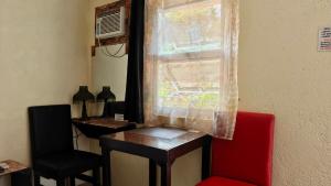 a room with a window with a table and a chair at Casa FAM in Laoag