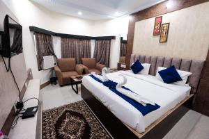 a bedroom with a large bed with blue and white pillows at Hotel Sapphire International in Puri +25 photos
