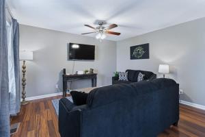 a living room with a blue couch and a ceiling fan at Crossroads Cottage l Grill & high speed internet in Chattanooga
