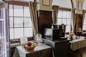 a kitchen with two tables with a basket of fruit at Hotel Havelser Hof in Garbsen