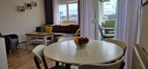 a living room with a table with a bowl of fruit on it at Opal Skay Apartment in Doboj +14 photos