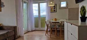 a kitchen with a table and chairs and a window at Opal Skay Apartment in Doboj
