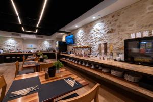 a restaurant with tables and chairs and a bar at Artion City Boutique Hotel in Heraklio