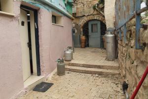 an alley with two trash cans in front of a building at חדשה בעתיקה - צפת in Safed