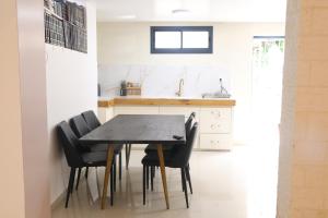 a kitchen with a black table and black chairs at חדשה בעתיקה - צפת in Safed