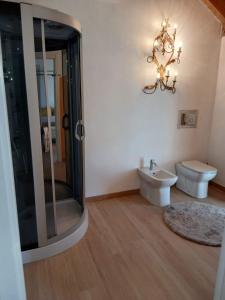 a bathroom with a shower and a toilet and a chandelier at Casa Carlotta in Perledo +50 photos