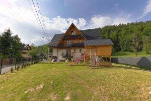 a house with a playground in the yard at Willa Mamcorka in Poronin