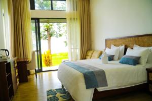a bedroom with a large bed and a large window at Eben Lake Kivu cottages and Villas in Kagano