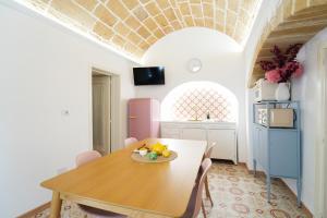 a dining room with a table and a kitchen at Pantabrì - Casa Tipica su Mare nel Centro Storico di Gallipoli in Gallipoli