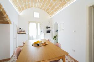 a dining room with a wooden table and chairs at Pantabrì - Casa Tipica su Mare nel Centro Storico di Gallipoli in Gallipoli