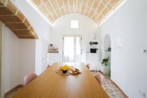 a dining room with a wooden table and white walls at Pantabrì - Casa Tipica su Mare nel Centro Storico di Gallipoli in Gallipoli +79 photos