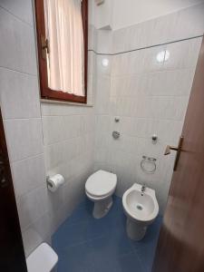 a small bathroom with a toilet and a sink at Home Sisters in Trapani +19 photos