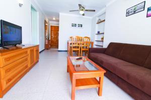 a living room with a couch and a tv and a table at Dms Planet Costa Dorada in La Pineda