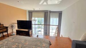 a bedroom with a bed and a flat screen tv at Mosaic condominium AD63M in Ban Tha Fat