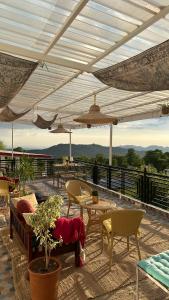 a patio with tables and chairs on a roof at Bir Haus in Bīr