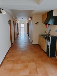 an empty hallway of a kitchen with a floor at Guest House Bamboo in Morioka