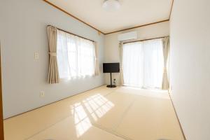 an empty living room with white walls and windows at AQUAMARINE HOTEL Nagahama in Nagahama