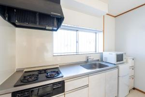 a kitchen with a sink and a microwave at AQUAMARINE HOTEL Nagahama in Nagahama