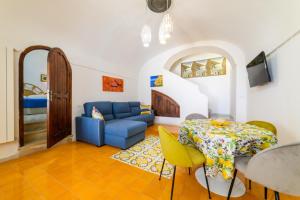 a living room with a blue couch and a table at Estate4home - Casa Bouganville in Positano