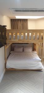 a wooden bunk bed with white sheets and pillows at Regen Hotel in Seoul