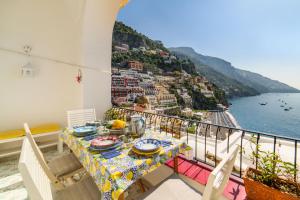 a table on a balcony with a view of the ocean at Estate4home - Casa Bouganville in Positano