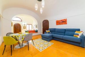 a living room with a blue couch and a table at Estate4home - Casa Bouganville in Positano