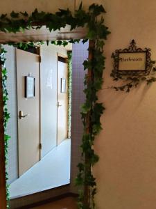 an entrance to a hallway with ivy on the wall at Guest House Bamboo in Morioka