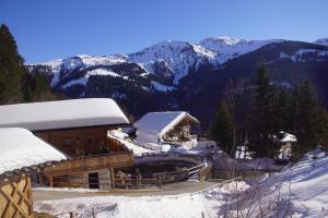 a building covered in snow with mountains in the background at READYNOW Alpine Resonanz Camp für mentale Klarheit in Pill +21 photos