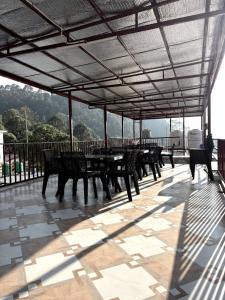 a group of tables and benches under a roof at Rautela Homestay in Lansdowne +2 photos