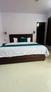a bedroom with a large bed with blue pillows at Rautela Homestay in Lansdowne