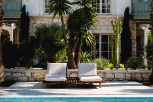 two chairs sitting next to a swimming pool at Fiora Alacati in Alaçatı