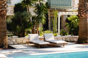 two lounge chairs next to a swimming pool at Fiora Alacati in Alaçatı