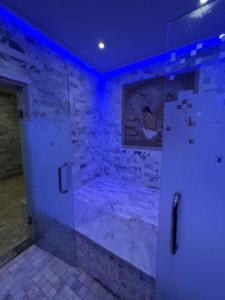 a bathroom with a walk in shower with blue lights at Houch Ennejma, Chambres d'hotes, Spa et bien être in Al Ḩārah al Kabīrah +43 photos