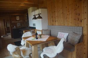 a dining room with a table and two white chairs at READYNOW Alpine Resonanz Camp für mentale Klarheit in Pill