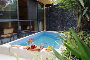 a swimming pool with a tray of food next to a house at Chengdu Xiaoya Courtyard Hot Spring Retreat -- Close to Panda Base & Sanxingdui Museum- Private Hot Spring & Sichuan Cuisine - Chinese Tea Ceremony, Free Breakfast, Afternoon Tea & Goodnight Snacks in Chengdu