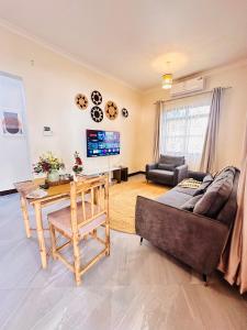 a living room with a couch and a table at Easyhomes bungalow apartment in Dar es Salaam